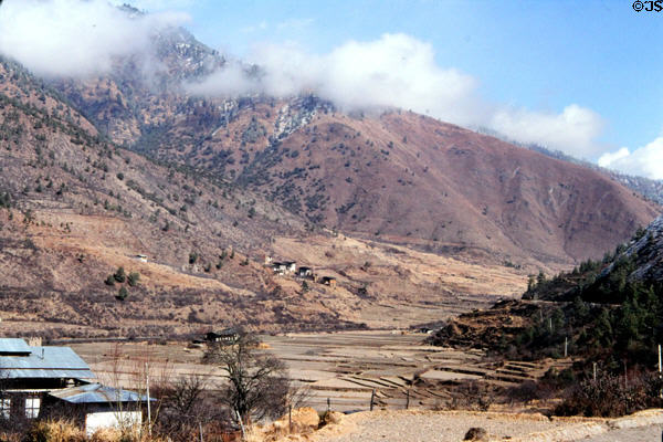 Farmland at foot of mountains surrounding between Paro & Thimpu. Bhutan.