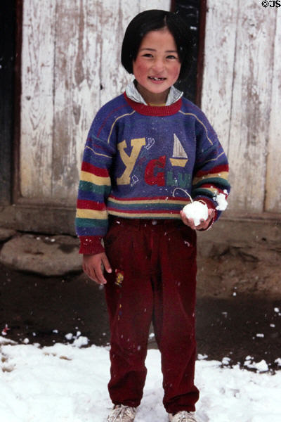 Child playing with snow on road to Punaka from Thimpu. Bhutan.