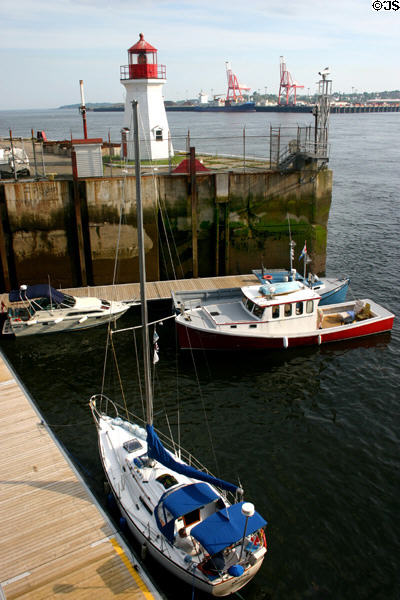 Small boats sit beneath small lighthouse in downtown Saint John. Saint John, NB.