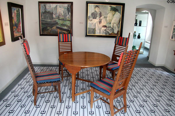 Round dining table with chairs covered of striped woven upholstery (c1920) by Wenzel Hablik at Schleswig Holstein State Museum. Schleswig, Germany.