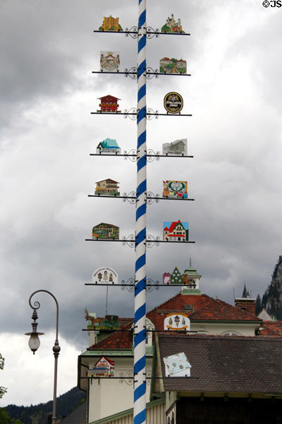 Maypole in Hohenschwangau with directions signs to nearby attractions. Füssen, Germany.