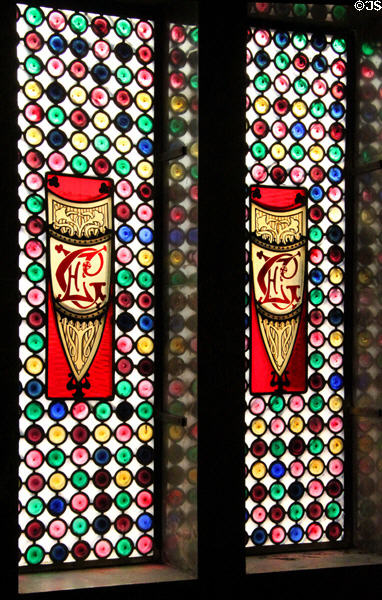 Stained glass window with EG (Eusebi Güell) initials over stairs on main floor at Palau Güell. Barcelona, Spain.