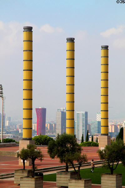 Light columns on plaza of 1992 Olympic Games with modern highrises in distance. Barcelona, Spain.