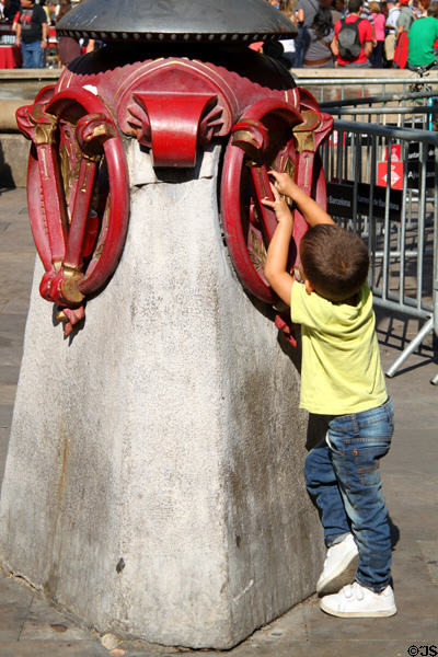 Young boy at Lampstand by Antoni Gaudí in Plaça Reial. Barcelona, Spain.
