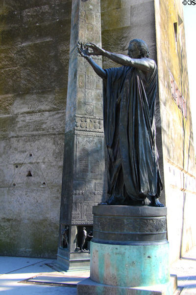 Statue of a man inviting onlookers to read texts on Monument of Human Rights (1992) on Champs de Mars. Paris, France.