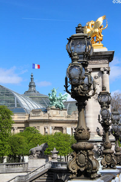 Row of Art Nouveau lamps on Pont Alexandre III with Grand Palais beyond. Paris, France.