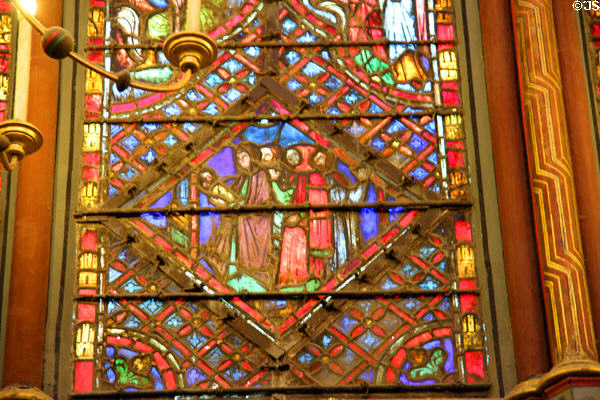 Mother & swaddled child with Three Kings stained glass scene at St Chapelle. Paris, France.