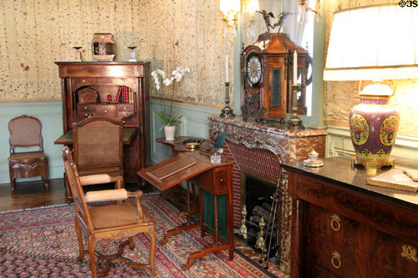 Fireplace with mantle clock flanked by desks, chairs & cabinet in birth chamber at Cheverny Chateau. Cheverny, France.