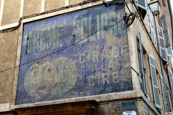 Antique commercial sign on wall of old town building. Aix-en-Provence, France.