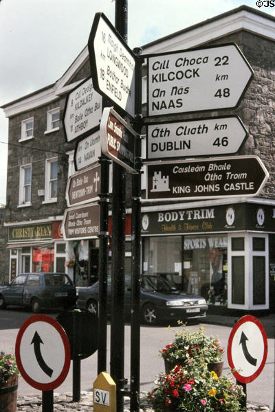 Typical bilingual directional signs on roundabout. Trim, Ireland.