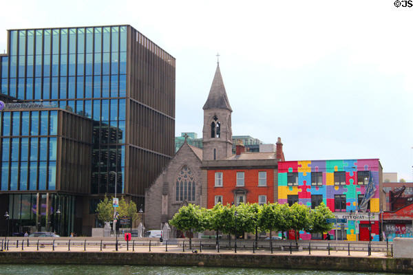 Immaculate Heart of Mary Church & converted warehouse with puzzle-piece mural on City Quai of River Liffey. Dublin, Ireland.