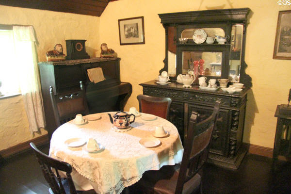 Dining table, piano & carved & mirrored sideboard in Mountain Farmhouse at Bunratty Castle & Folk Park. County Clare, Ireland.