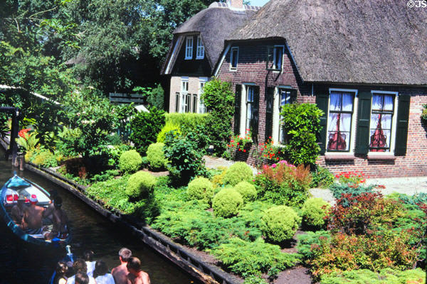 Lush gardens beside the river. Giethoorn, Netherlands.