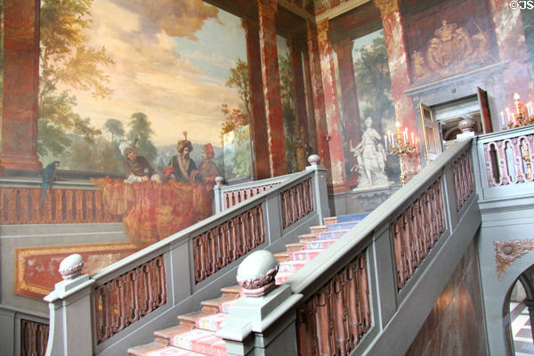 Grand Staircase, with mural depicting richly dressed Ottoman men, standing behind painted balustrade. Het Loo, Netherlands.
