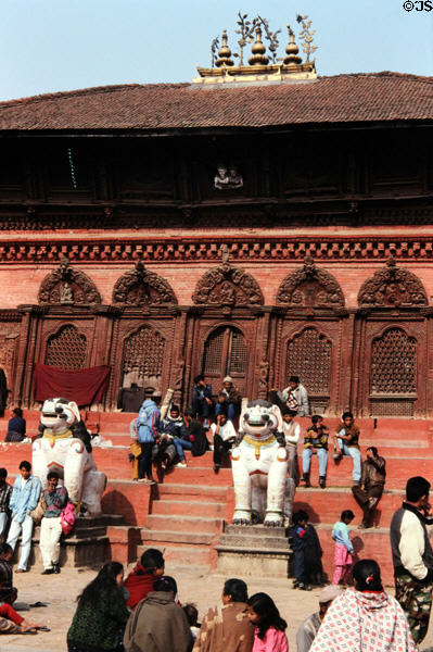 People sunning on temple steps in Durbar Square, Katmandu. Nepal.