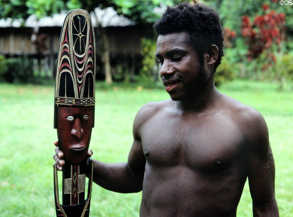 Carver posing with his artwork near the house Tambaran in Wambun. Papua New Guinea.