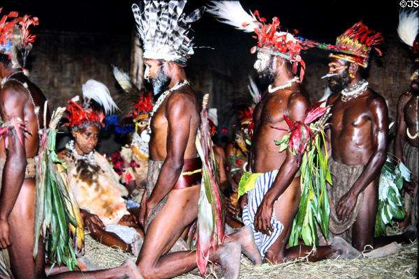 Men on knees approach women during a courtship ritual near Banz. Papua New Guinea.