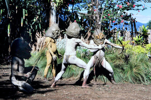 Archers with huge mud masks perform in the Mudmen village. Papua New Guinea.