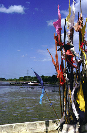 Prayer flags over the water at the Hindu Temple at Waterloo. Trinidad and Tobago.