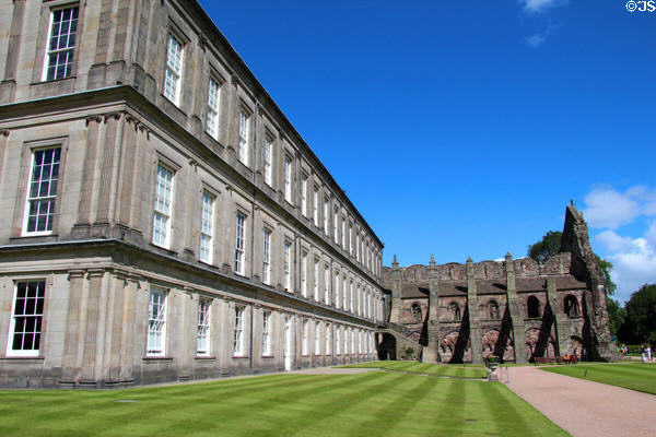 Neoclassical facade of Holyrood Palace by William Bruce with Holyrood Abbey beyond. Edinburgh, Scotland.