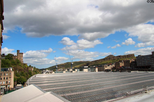 Salisbury Crags over glass roof of Waverley railway station. Edinburgh, Scotland.