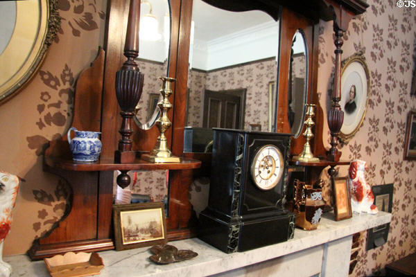 Clock & other objects on parlor fireplace at Tenement House museum. Glasgow, Scotland.