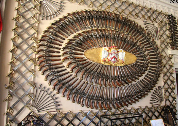 Collection of arms, some bought in 1812 when obsolete, around crest in Armory at Culzean Castle. Maybole, Scotland.