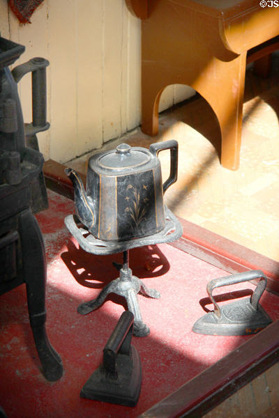 Metal teapot on stand in D MacPherson Tailor & Outfitter shop at Highland Folk Museum. Newtonmore, Scotland.