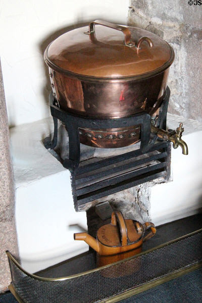 Copper water heater on fireplace grate at Craigievar Castle. Alford, Scotland.
