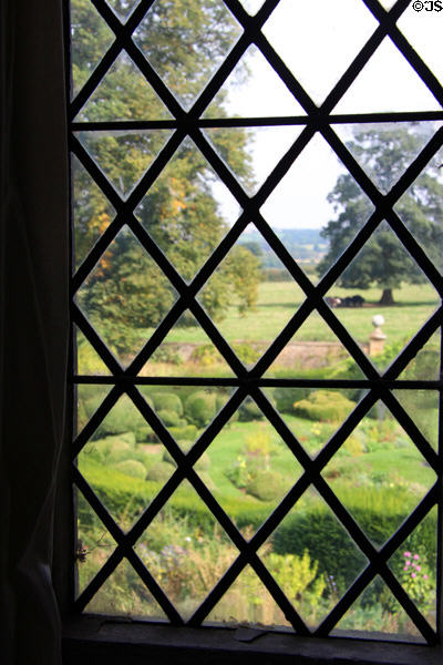 Gardens viewed through leaded window at Chastleton House. Moreton-in-Marsh, England.