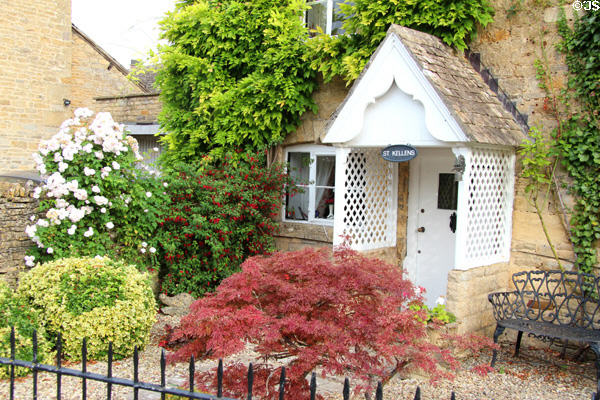 St Kellens historic listed building with front yard filled with shrubbery. Lower Slaughter, England.