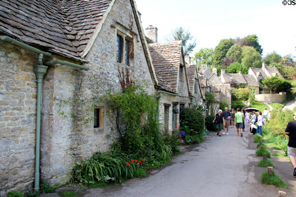 Visitors stroll along Arlington Row pathway. Bibury, England.