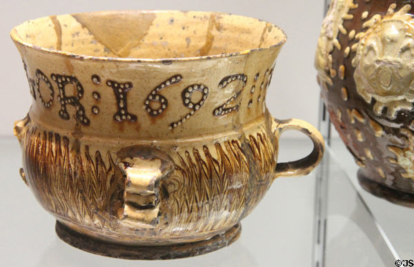Glazed earthenware posset pot (1692) inscribed George Taylor from Straffordshire at Potteries Museum & Art Gallery. Hanley, Stoke-on-Trent, England.