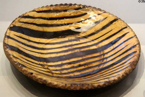 Slipware dish on buff earthenware body with lead glaze (late 17thC) typical of Stoke region at World of Wedgwood. Barlaston, Stoke, England.