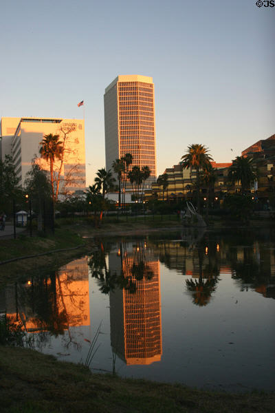Buildings on Wilshire Boulevard reflect setting sun into La Brea tar pits. Los Angeles, CA.