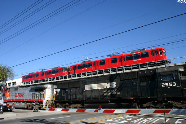 Trolley passes above BNSF train. CA.