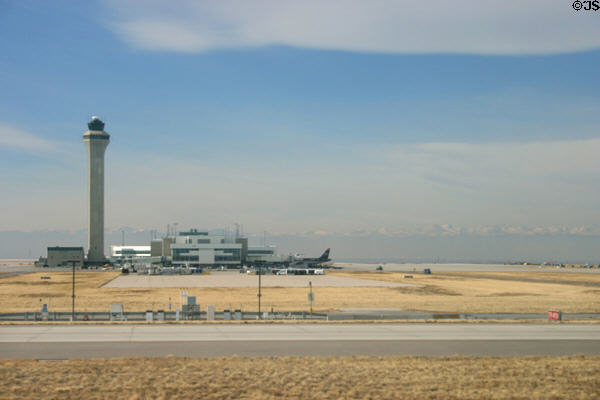 Control Tower against Rocky Mountains at Denver International Airport from runway. Denver, CO.