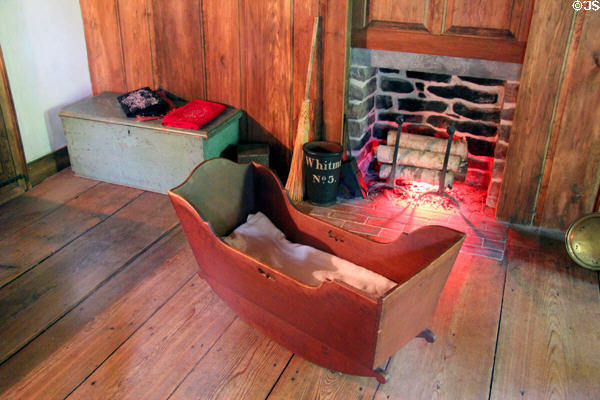 Cradle before fireplace at Stanley-Whitman House. Farmington, CT.