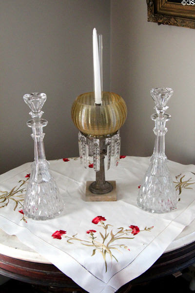 Cut glass decanters & candle luster on embroidered cloth at Isham-Terry House Museum. Hartford, CT.