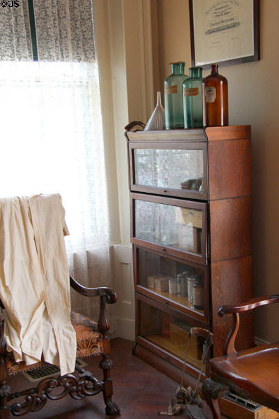 Sectional glass-fronted bookshelves with medical bottles at Isham-Terry House Museum. Hartford, CT.