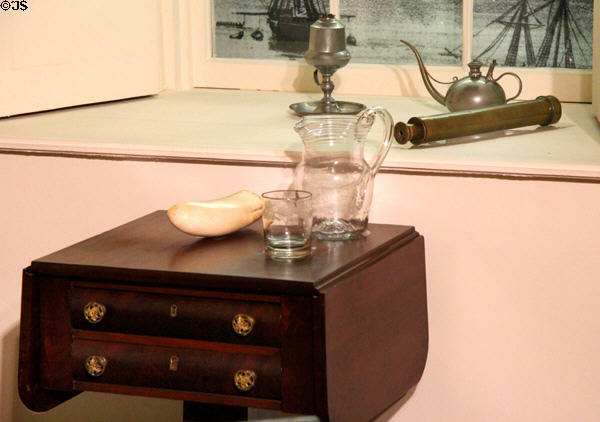 Work table (1830-40), glass pitcher & tumbler, whale tooth, telescope, whale oil lamp, & oil lamp filler with long spout in California period parlor at DAR Memorial Continental Hall. Washington, DC.
