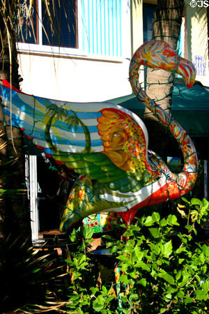 Brightly painted plastic flamingo stands on Ocean Drive. Miami Beach, FL.