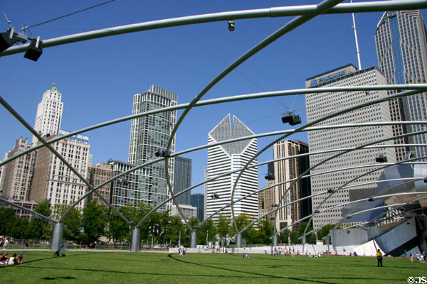 Skyscrapers along Michigan Av. & Randolph St. seen through latticework trellis covering of lawn seating area for Gehry's Pritzker Pavilion in Millennium Park. Chicago, IL.