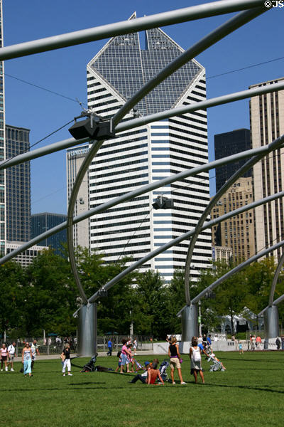 Smurfit-Stone Building seen through latticework covering of lawn seating area for Gehry's Pritzker Pavilion in Millennium Park. Chicago, IL.
