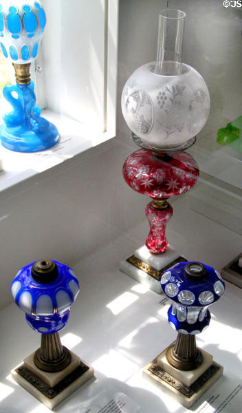 Collection of colored cut overlay glass lamps by Boston & Sandwich Glass Co. at Sandwich Glass Museum. Sandwich, MA.