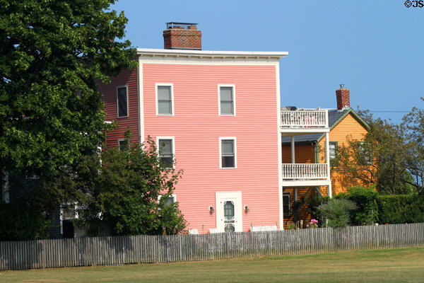 Pink & yellow heritage houses on field leading to Salem's Central Wharf. Salem, MA.