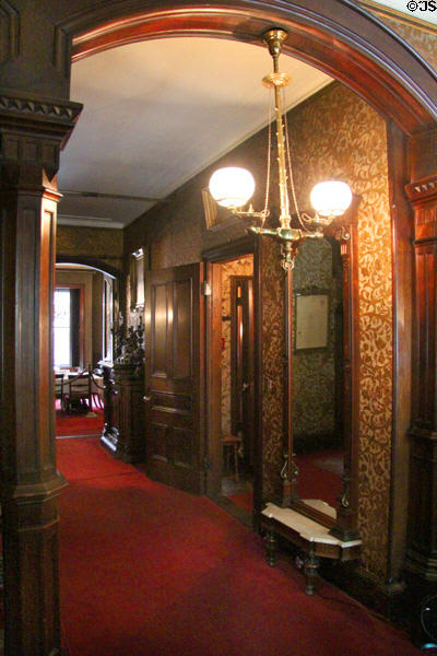 Hallway with gas lamp leads to dining room, only room on ground floor, at Gibson House Museum. Boston, MA.