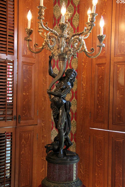 Sconce of woman holding chandelier in dining room at Campbell House Museum. St. Louis, MO.