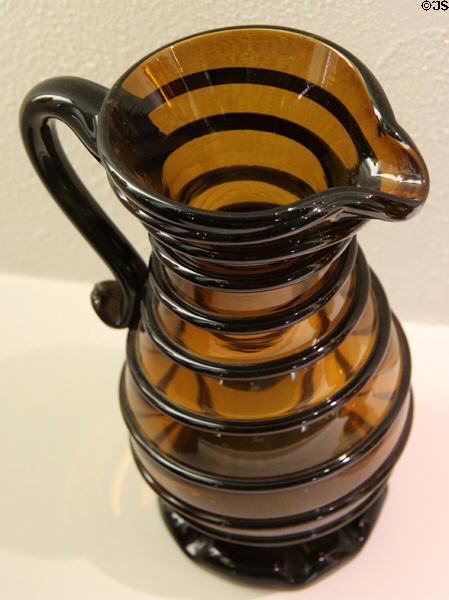 Amber glass pitcher wound with threads (c1880) by Whitney Glass Works of Glassboro, NJ at Museum of American Glass. Milville, NJ.