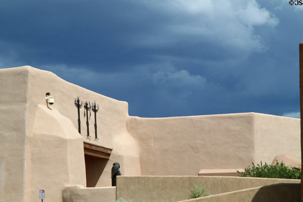 Museum of Indian Arts & Culture in sun under threatening sky. Santa Fe, NM.